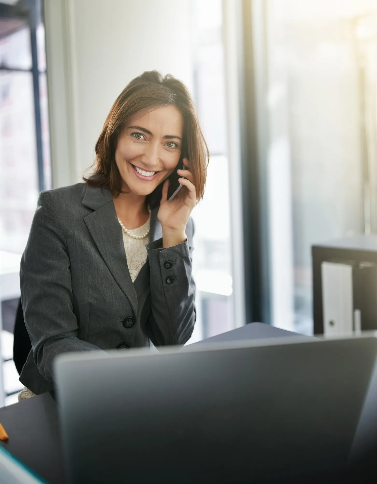 A real estate professional on a call by a window